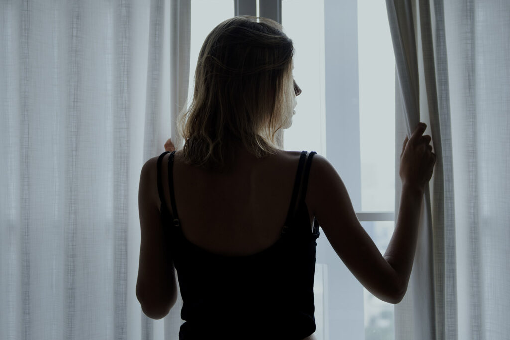 woman standing alone by the window, isolated